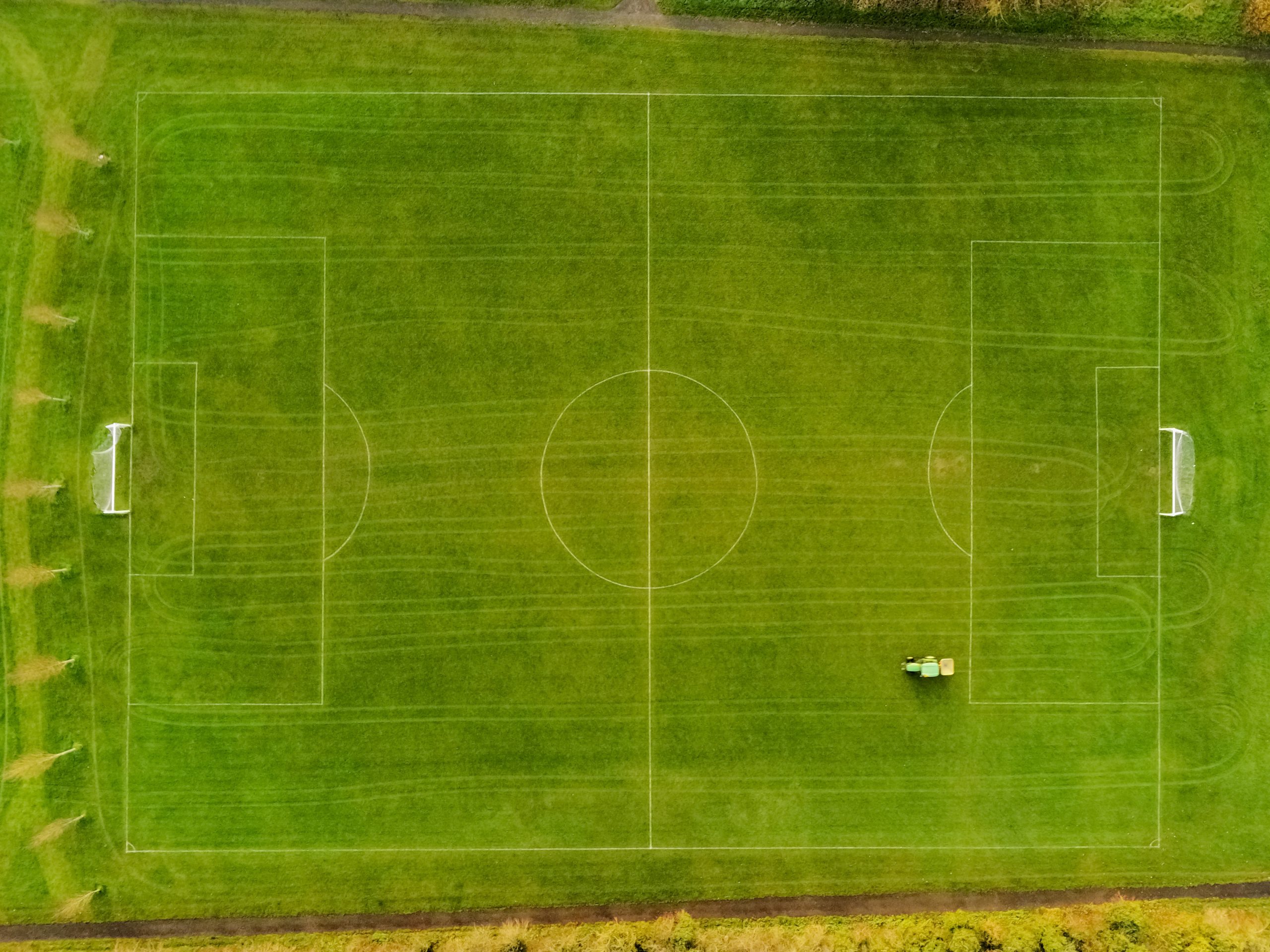 football field under maintenance, Tractor with trail all over the pitch