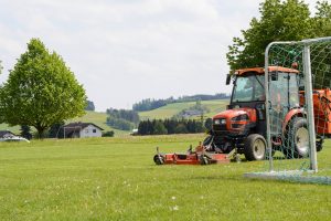 Compact tractor on sports field