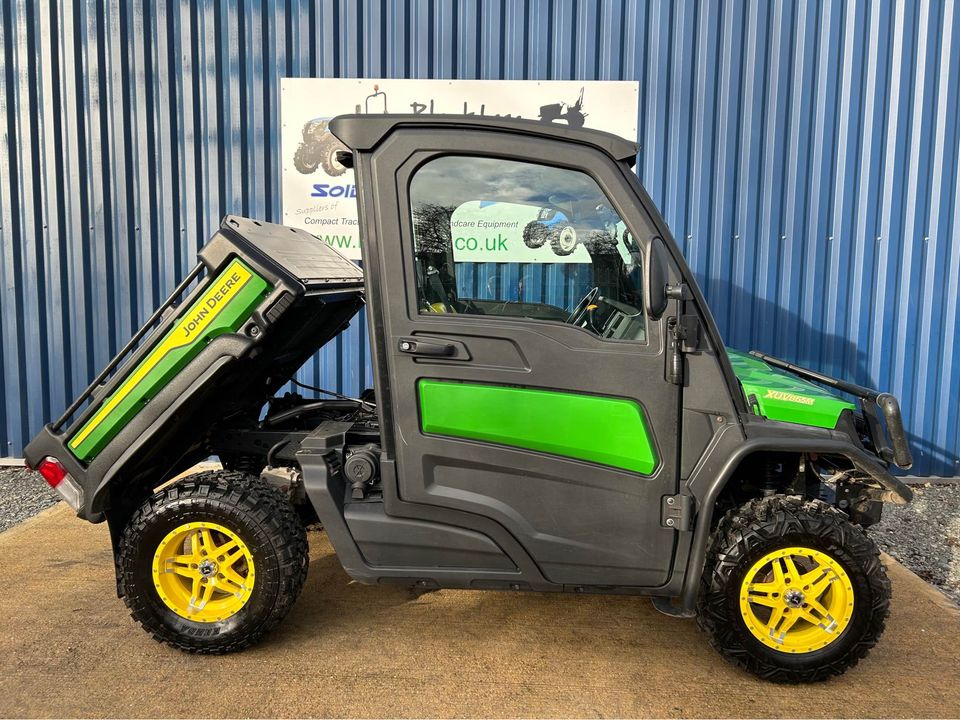 Side view of John Deere XUV865M Gator 4WD Diesel Utility Vehicle with back tipped