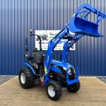 Front view of Solis 26HST Compact Tractor with Loader and Hydraulic Grab Bucket with loader raised and bucket open