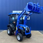 Front view of new Solis 26HST (Hydrostatic) Compact Tractor with Cab, Loader & Grab Bucket with loader raised
