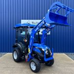 Front view of new Solis 26HST (Hydrostatic) Compact Tractor with Cab, Loader & Grab Bucket with loader raised
